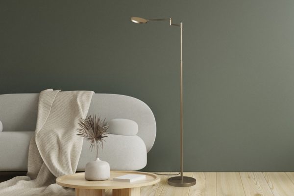 Satin brass Holtkötter floor lamp beside modern sofa – warm and stylish