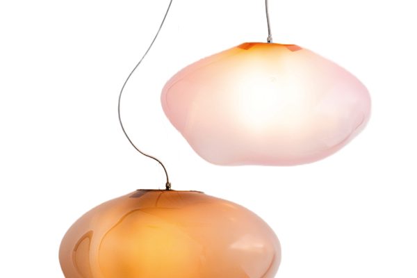 Two hand-blown glass pendant lights by ELOA in warm amber and rose tones, suspended as floating sculptures