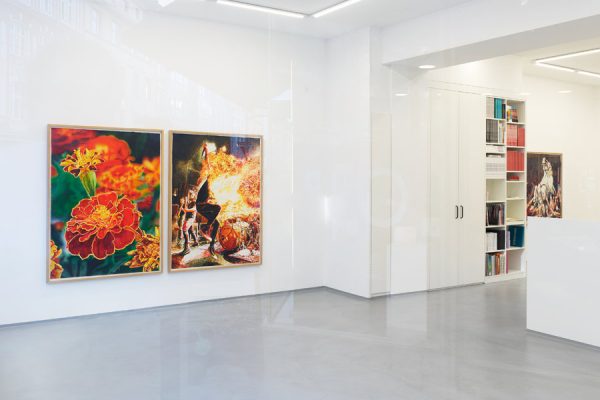 Gallery space with art on the walls and a curated book display at Galerie Droste