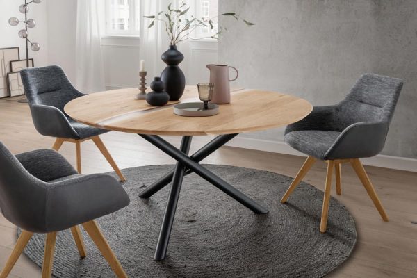 Round designer table with metal legs and surrounding chairs by PLH