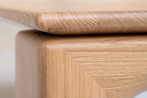 Detail view of Rodam table leg and edge – elegant material transition with refined woodwork.