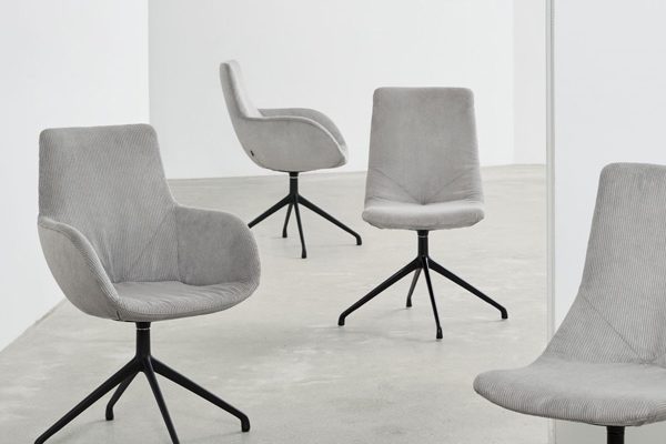 Four upholstered swivel armchairs by Werther in a museum-like setting – sleek and refined design presentation.