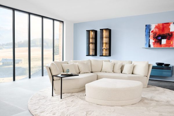 Bright white sofa with accent pillows in airy showroom by Werther