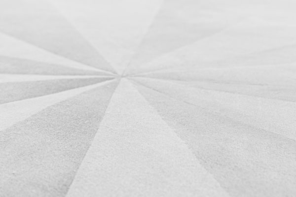 Close-up of the light grey rug showing radial gradient design in soft shades.