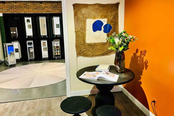 518 North showroom – NIRU sculptural black table with stools and contemporary wall art in the foreground, with BoardBar aviation trolleys displayed in the adjacent room