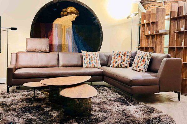 518 North showroom – ‘The Flat’ wall art as the focal point, with KPM porcelain displayed on open shelving, complemented by Holtkötter lighting and a Werther leather sectional